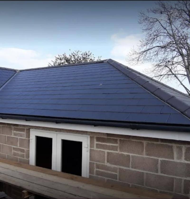 Fibre cement slate roof with matching hip and ridge details on a brick garage build