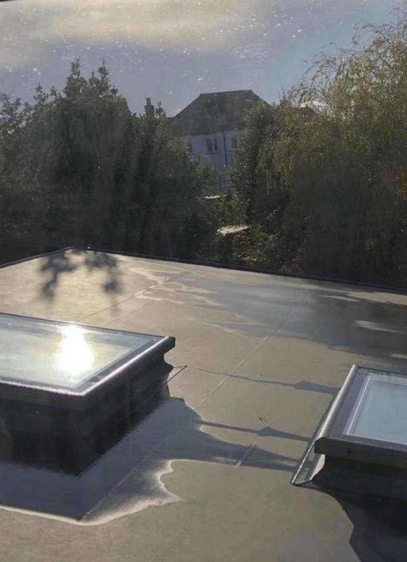 Single-ply flat roof with two raised glazed rooflights and neatly sealed membrane junctions