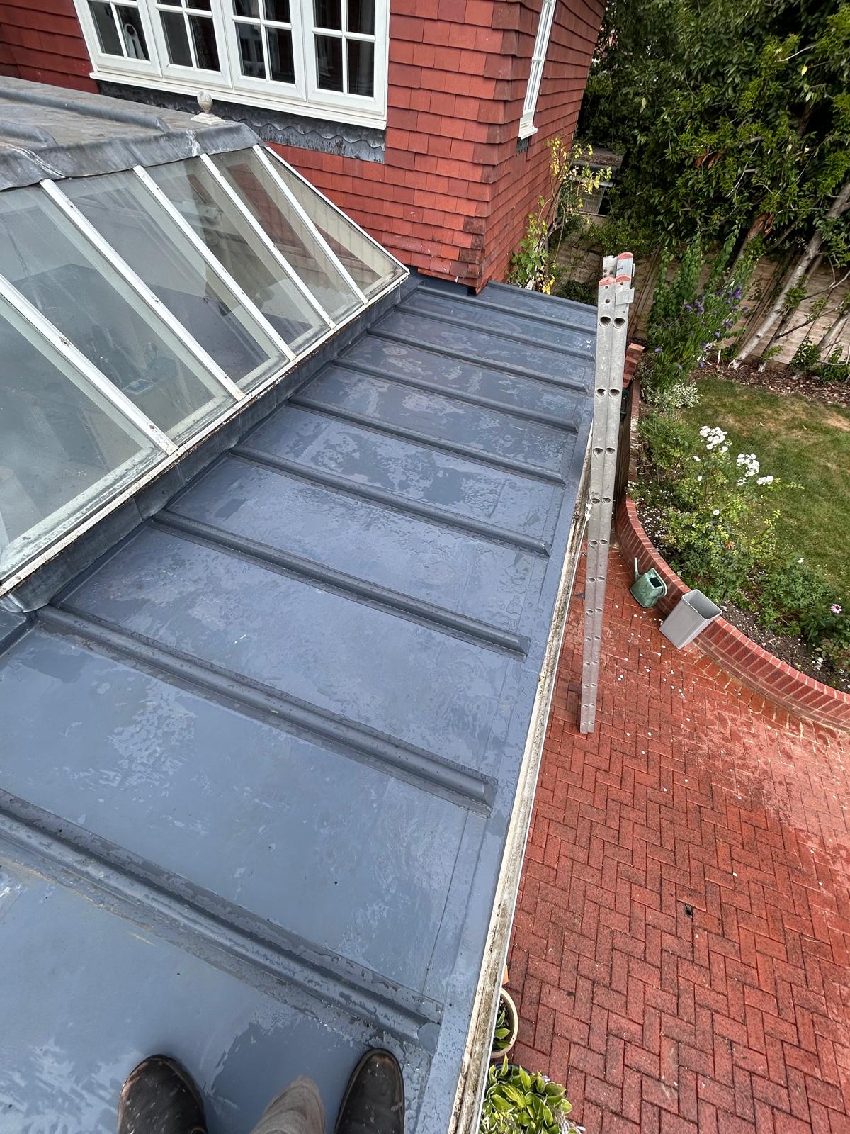 Roll-jointed lead roof alongside a glazed lantern, with raised lead rolls and carefully dressed junctions at the glazing