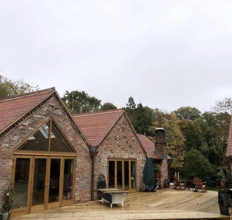 Clay tiled roofs with decorative ridge details on a brick barn conversion