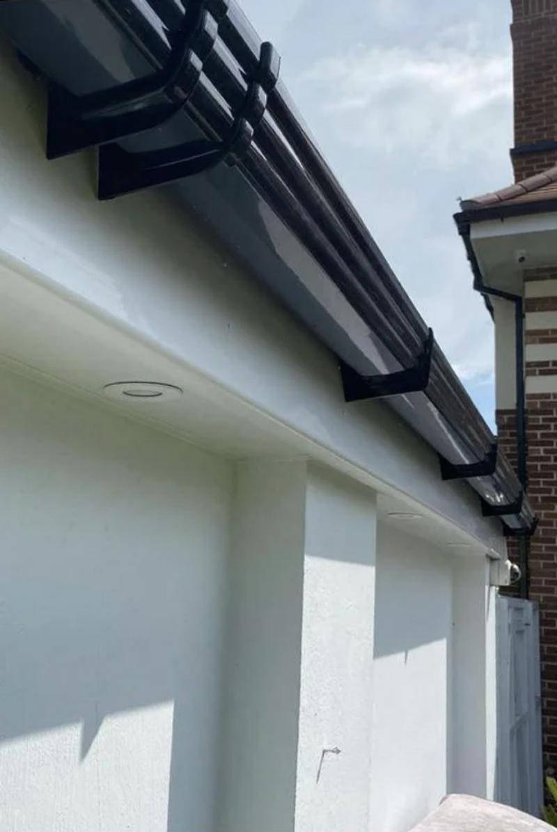 New black guttering and fascia along the eaves with white soffits beneath