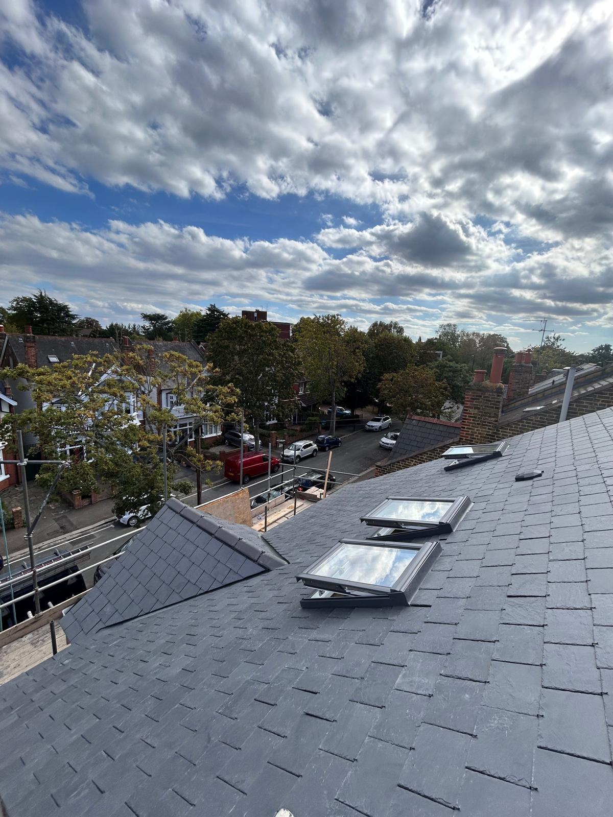 Natural slate re-roof with three Velux roof windows set into the slope and an adjoining slate dormer roof